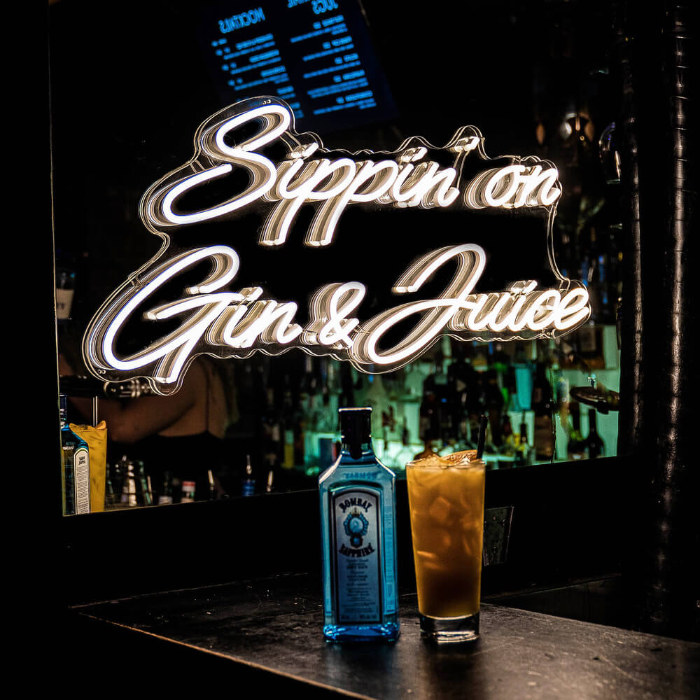 sippin on gin and juice neon sign in bar