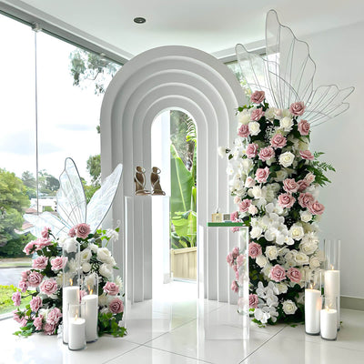 white 3d arch backdrop with led butterflies and pink and white rose flower arrangements
