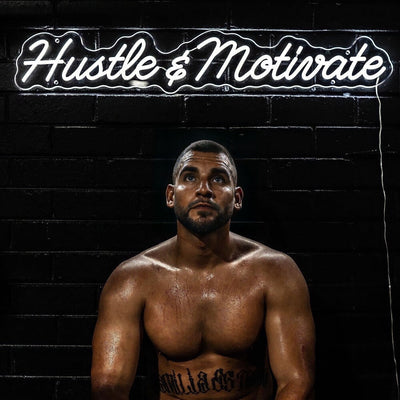 white hustle and motivate neon sign on gym wall