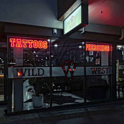 tattoo neon sign hanging in tattoo shop front window