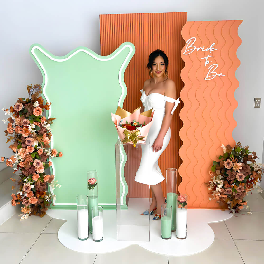 girl standing in front of green and orange backdrops with terracotta flowers and sand candles