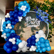 white let's get this party started neon sign hanging on circle backdrop with blue flower arrangement and large balloon arch