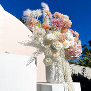 colourful flower arrangement in white vase standing on white limestone plinth