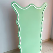 green curly backdrop board with white trimming standing on tiles