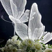 white led butterflies sitting on top of white flower arrangement