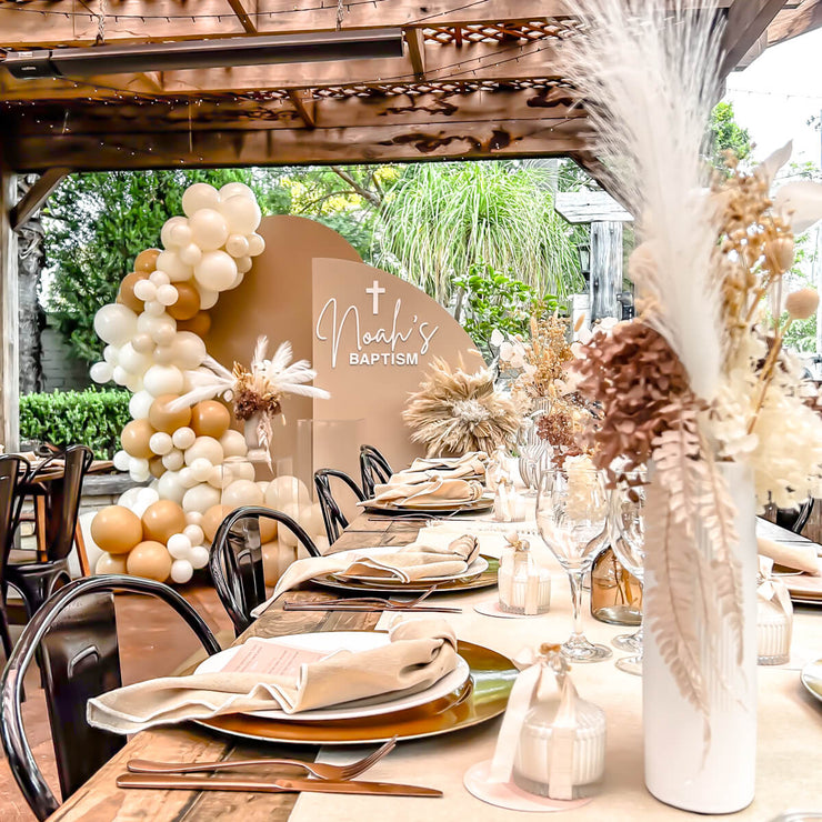 boho themed table decor with beige backdrops, balloons and flower arrangements