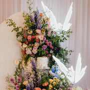 white led butterflies floating on top of wild flower arrangement with cake in centre