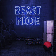 blue beast mode neon sign hanging on gym wall