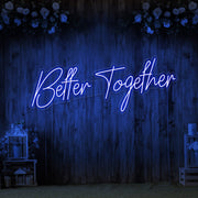blue better together neon sign hanging on timber wall