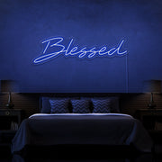 blue blessed neon sign hanging on bedroom wall