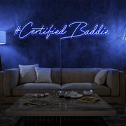 blue certified baddie neon sign hanging on living room wall