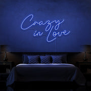 blue crazy in love neon sign hanging on bedroom wall