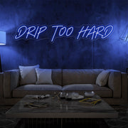 blue drip too hard neon sign hanging on living room wall