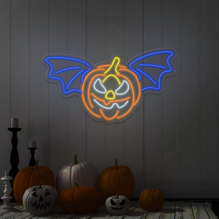 blue flying pumpkin neon sign hanging on wall above pumpkins