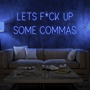 blue lets fuck up commas neon sign hanging on living room wall