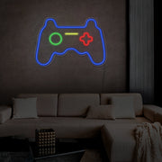 blue gaming controller neon sign hanging on living room wall