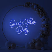 blue good vibes only neon sign hanging inside balloon hoop backdrop