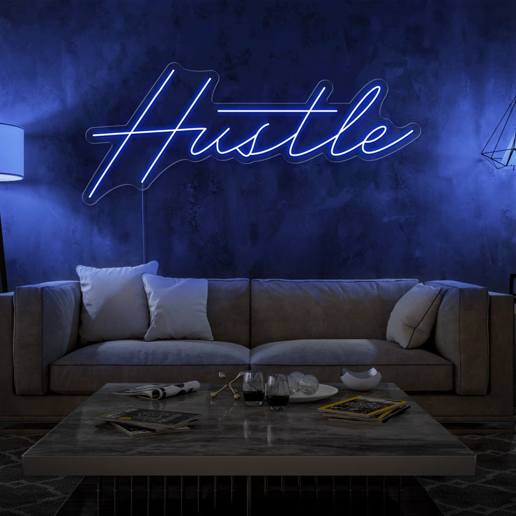 blue hustle neon sign hanging on living room wall