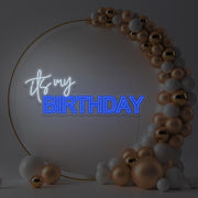 blue it's my birthday neon sign hanging in gold hoop backdrop with balloons