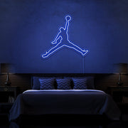 blue jordan jumpman neon sign hanging on bedroom wall