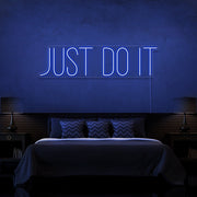 blue just do it neon sign hanging on bedroom wall