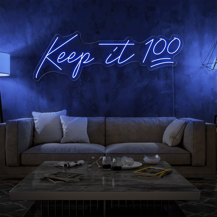 blue keep it 100 neon sign hanging on living room wall