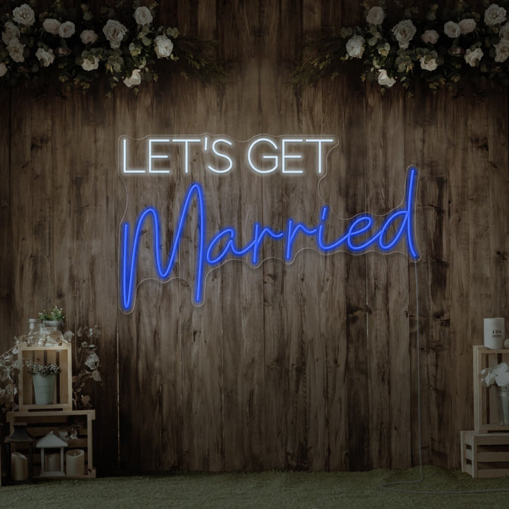 blue lets get married neon sign hanging on timber wall