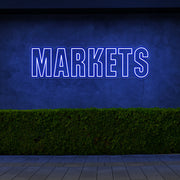 blue markets neon sign hanging on outside wall