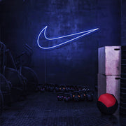blue nike swoosh neon sign hanging on gym wall