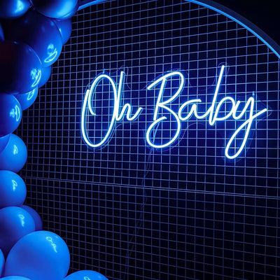 blue oh baby neon sign hanging on white mesh backdrop frame