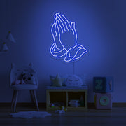 blue praying hands neon sign hanging on kids bedroom wall