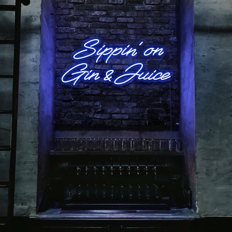 blue sippin on gin and juice neon sign hanging on bar wall