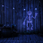 blue skeleton neon sign hanging on timber fence