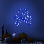 blue skull bones neon sign with pumpkins on floor