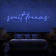 blue sweet dreams neon sign hanging on bedroom wall