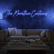 blue the marathon continues neon sign hanging on living room wall