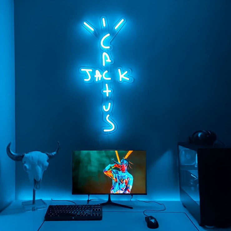 blue travis Scott neon sign hanging on computer room wall