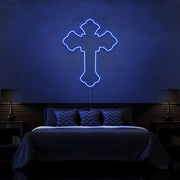 blue tupac cross neon sign hanging on bedroom wall