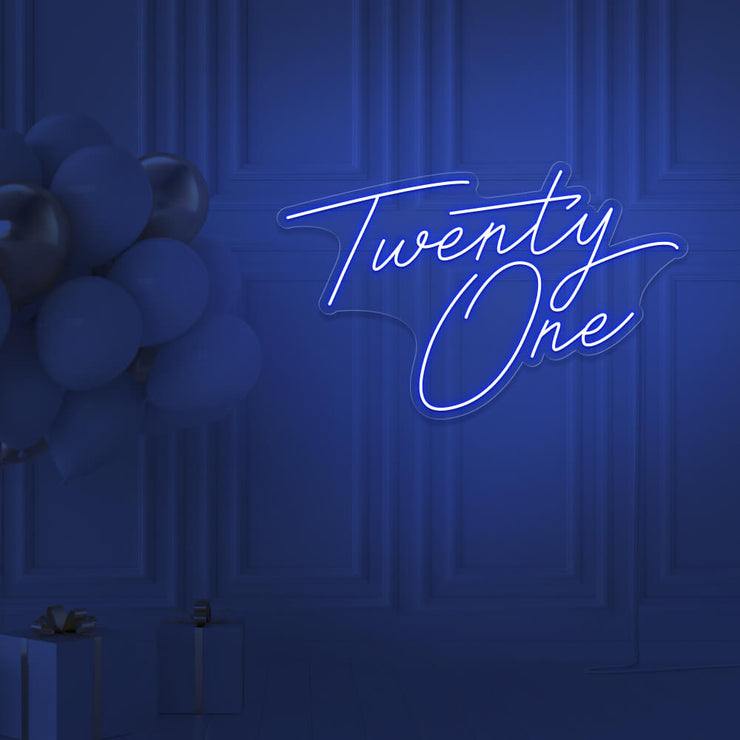 blue  twenty one neon sign hanging on wall with balloons