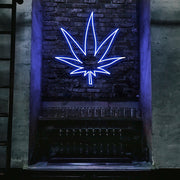 blue weed leaf neon sign hanging on bar wall