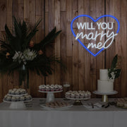 blue will you marry me heart neon sign hanging on timber wall above dessert table