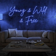 blue young and wild and free neon sign hanging on living room wall