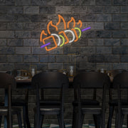 chicken skewer neon sign hanging above table on wall