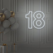 cold white 18 neon sign hanging on wall with balloons
