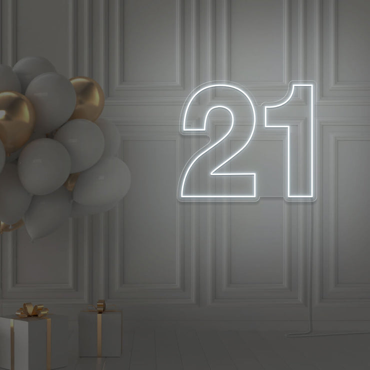 cold white 21 neon sign hanging on wall with balloons