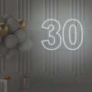cold white 30 neon sign hanging on wall with balloons