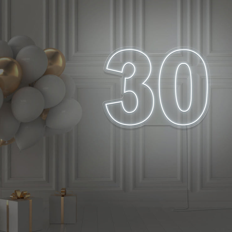 cold white 30 neon sign hanging on wall with balloons
