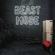 cold white beast mode neon sign hanging on gym wall