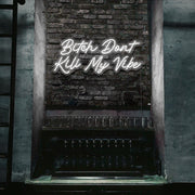 cold white bitch don't kill my vibe neon sign hanging on bar wall