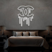 cold white dripping chanel neon sign hanging on bedroom wall